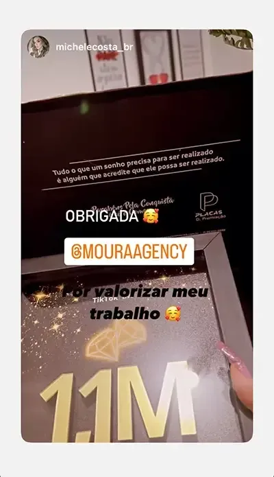 Streamer Michele com a placa de reconhecimento da agência